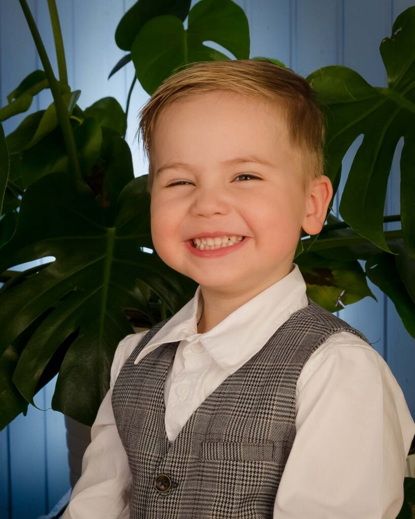 Junge im Bilderzimmer Fotostudio, lacht in die Kamera